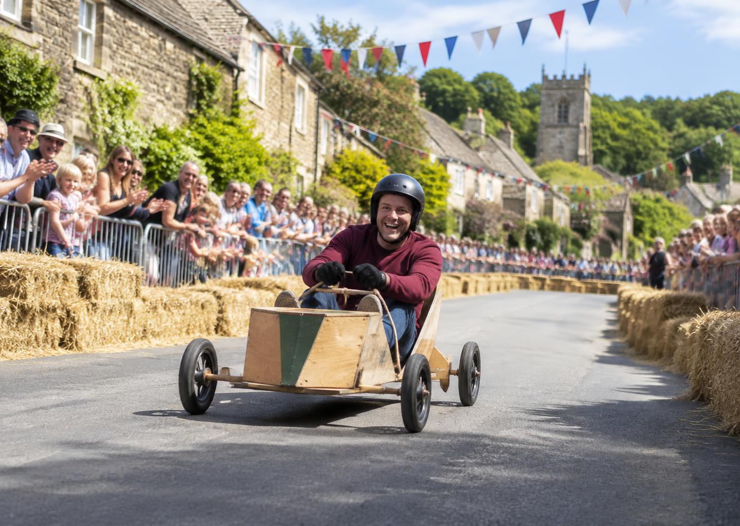 Illustrative village soapbox race with spectators lining the course